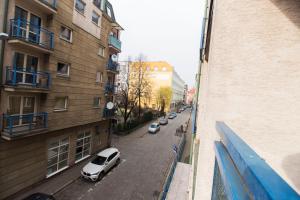 a white car parked on a street next to a building at HAPPYESTATE ul Biskupia 3 min do Rynku in Wrocław