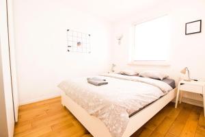 a white bedroom with a bed and a window at HAPPYESTATE ul Biskupia 3 min do Rynku in Wrocław