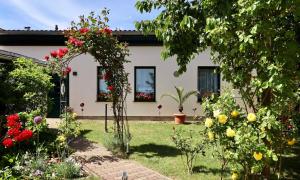 un jardin fleuri devant une maison dans l'établissement "Das Ferienhaus Waren" Objekt ID 12035-8, à Waren