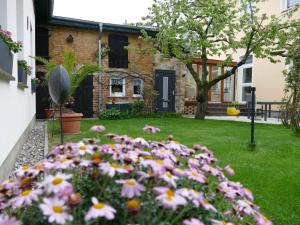un jardin avec des fleurs roses en face d'une maison dans l'établissement "Das Ferienhaus Waren" Objekt ID 12035-8, à Waren