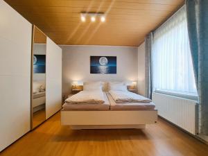 une chambre avec un lit et une grande fenêtre dans l'établissement "Das Ferienhaus Waren" Objekt ID 12035-8, à Waren 10 autres photos