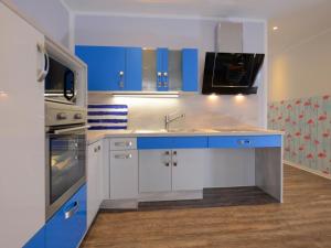 a kitchen with blue and white cabinets and a sink at Florida App 1 Montag in Boltenhagen