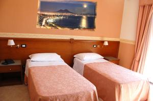 a hotel room with two beds and a painting on the wall at Hotel Ristorante Donato in Calvizzano