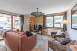 ein Wohnzimmer mit Sofa, Sesseln und Fernseher in der Unterkunft Alpe d'Huez Houses - Chez Cathy - Fermes de l'Alpe - Fabuleux 2 chambres neuf pour 6 personnes in L'Alpe-d'Huez