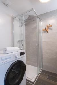eine Waschmaschine in einem Badezimmer mit Dusche in der Unterkunft Alpe d'Huez Houses - Chez Cathy - Fermes de l'Alpe - Fabuleux 2 chambres neuf pour 6 personnes in L'Alpe-d'Huez + 25 Fotos