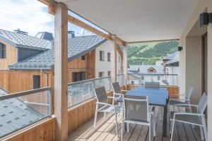 ein Balkon mit einem blauen Tisch und Stühlen in der Unterkunft Alpe d'Huez Houses - Chez Cathy - Fermes de l'Alpe - Fabuleux 2 chambres neuf pour 6 personnes in L'Alpe-d'Huez