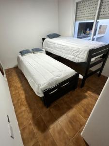 Dos camas individuales en una habitación con ventana. en Casa Nogoyá CON GARAJE, en Nogoyá