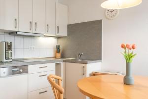 eine Küche mit einem Holztisch mit einer Blumenvase in der Unterkunft Seepark Sellin FeWo AG Whg 383 in Ostseebad Sellin
