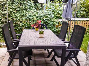 a wooden table with four chairs and an umbrella at Lütt Stuuv am Dorfanger in Barth