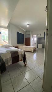 a bedroom with a bed and a tiled floor at Hotel e Restaurante Samburá in Olinda