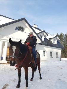 a man riding on a horse in the snow at Dawno Temu - Agroturystyka Premium in Lipowy Most