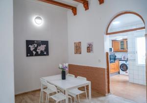 ValenciaにあるMediterranean Roomの白いテーブルと椅子のあるキッチンとダイニングルーム