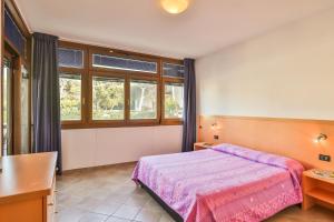a bedroom with a bed and a desk and window at La Lanterna in San Vincenzo