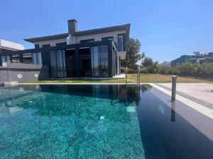 a swimming pool in front of a house at Villa Ant in Çeşme