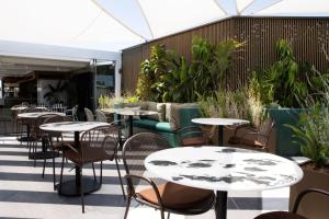 an outdoor patio with tables and chairs and plants at Luwian Athens Boutique Hotel in Athens +32 photos