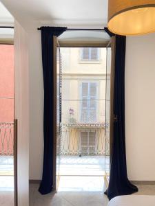 an open door to a balcony with black curtains at Paolina Home in La Spezia +7 photos