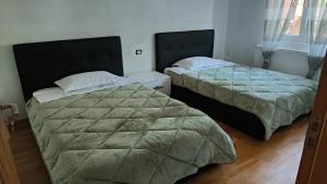 two beds sitting in a room with at Vila Ciciou in Negreşti-Oaş