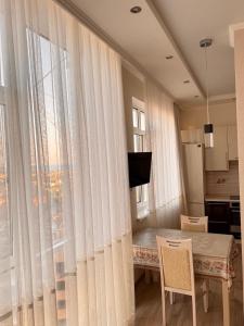 a living room with a table and a large window at Апартаменты-студия с видом на море ЖК Kadorr 10 жемчужина in Odesa