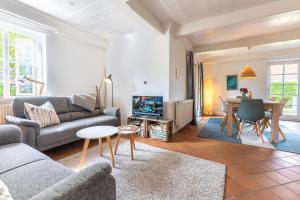 a living room with a couch and a tv and a table at Haus Kliffkante 2 Goting in Goting