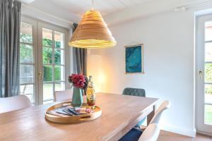 a dining room with a wooden table with a bottle of beer at Haus Kliffkante 2 Goting in Goting +14 photos