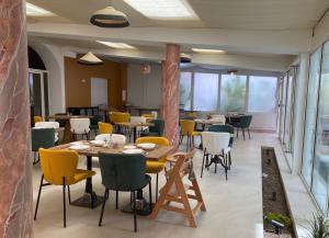 a dining room with tables and chairs and windows at Best Western Plus Sanary in Sanary-sur-Mer