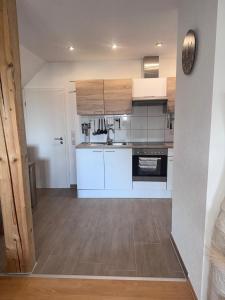 eine Küche mit weißen Geräten und Holzböden in der Unterkunft Ferienwohnung "Landblick" in Tecklenburg