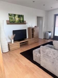 ein Wohnzimmer mit Flachbildfernseher und Couch in der Unterkunft Ferienwohnung "Landblick" in Tecklenburg + 9 Fotos