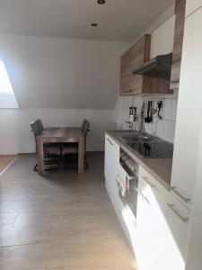 eine Küche mit einem Holztisch und einem kleinen Tisch in der Unterkunft Ferienwohnung "Landblick" in Tecklenburg
