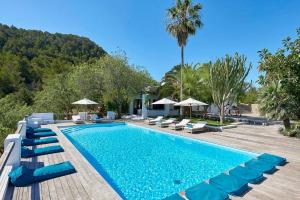 a swimming pool with lounge chairs and a resort at Elegant Villa Retreat in Ibiza's Heart, 1041 in Sant Josep de Sa Talaia