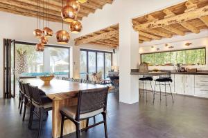 a kitchen and dining room with a wooden table and chairs at Elegant Villa Retreat in Ibiza's Heart, 1041 in Sant Josep de Sa Talaia