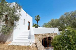 a white house with stairs and a tree at Elegant Villa Retreat in Ibiza's Heart, 1041 in Sant Josep de Sa Talaia