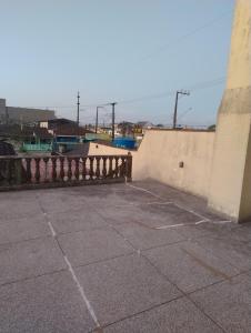 a parking lot next to a wall with a fence at Quarto kitnet in Matinhos +1 photo