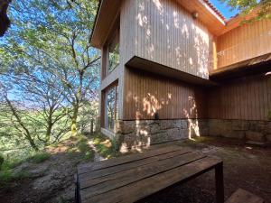 un banco de madera sentado fuera de una casa en Oak Villa, Relax and Nature, en Vieira do Minho