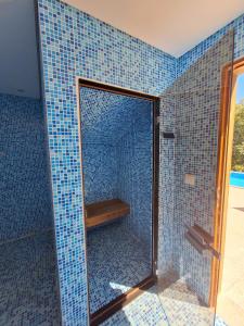 y baño con ducha de azulejos azules. en Oak Villa, Relax and Nature, en Vieira do Minho