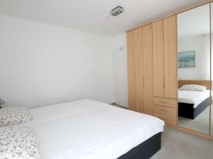 Un dormitorio con dos camas y un armario de madera. en Haus am Meer, Whg D06, en Boltenhagen 9 fotos más