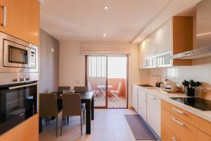 a kitchen with a table and a dining room at Apartamento Vista Marinha in Portimão
