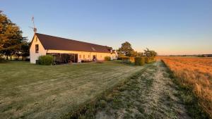 a barn with a windmill in the middle of a field at Wingårdhs B&B Österlen in Löderup
