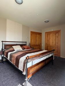 ein Schlafzimmer mit einem großen Bett und Holztüren in der Unterkunft Atpūtas komplekss "Pūķarags" in Pape