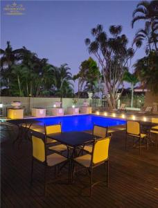 Un patio con mesa y sillas junto a una piscina. en The Presidential Mansion, en Durban