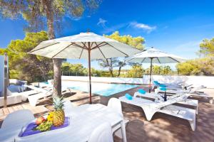 a pool with white chairs and tables and umbrellas at Exquisite 6 Bedroom Home in San Jose, 1068 in San Jose