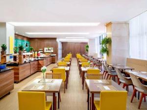 a restaurant with tables and yellow chairs and a cafeteria at Apartamento alto padrão dentro de hotel in Brasilia