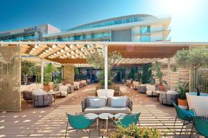 a patio with chairs and tables in front of a building at Radisson Blu Resort & Spa in Split