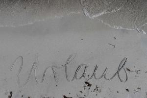 a word written in the sand on the beach at Ferienwohnung mit Meerblick, Balkon und Kamin OFC 06 in Roggow