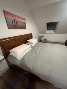a bedroom with a large bed with a wooden headboard at BlueWillowRetreat with Sauna Spiddal in Galway +29 photos