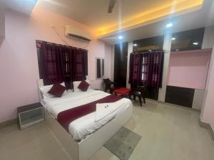 a bedroom with a large white bed in a room at Hotel Miracle Stay in Bhubaneshwar