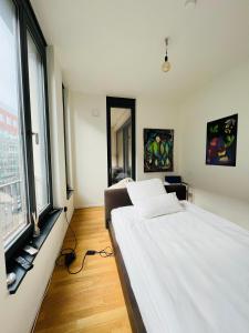 a bedroom with a white bed and a large window at Berlin -Central-Mitte Light Filled 2BD in Niederdorla