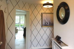 un couloir avec une horloge sur le mur dans l'établissement Haus Windrose, à Wrixum