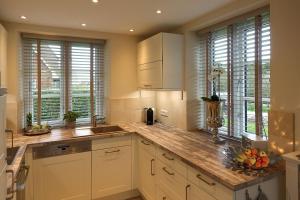 une cuisine avec des placards blancs et un comptoir avec des fruits. dans l'établissement Haus Windrose, à Wrixum