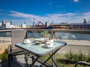a table on a balcony with a view of the water at Hafenspitze App 05 in Wismar