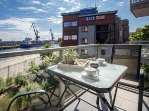 a table on a balcony with a view of a building at Hafenspitze App 05 in Wismar +18 photos